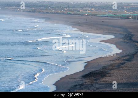 Wellen vom Pazifischen Ozean brechen am einsamsten Strand bei Sonnenaufgang in Arica, Chile. Stockfoto