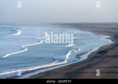 Wellen vom Pazifischen Ozean brechen am einsamen Strand bei Sonnenaufgang in Arica, Chile. Stockfoto