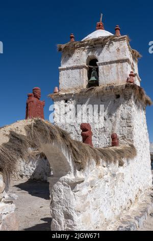 Der steinerne Glockenturm der Geburtskirche der Jungfrau Maria in Parinacota auf dem andenaltiplano in Chile. Lauca-Nationalpark. Stockfoto