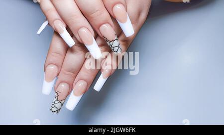 Verlängerung der Acrylnagel. Maniküre. Nagelkorrektur. Hände im Vordergrund. Platz kopieren. Stockfoto