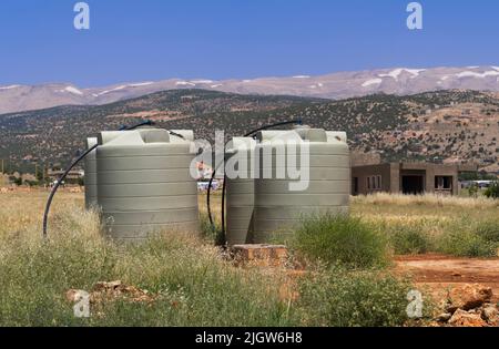 Wassertanks in einem Feld, Baalbek-Hermel Governorate, Baalbek, Libanon Stockfoto