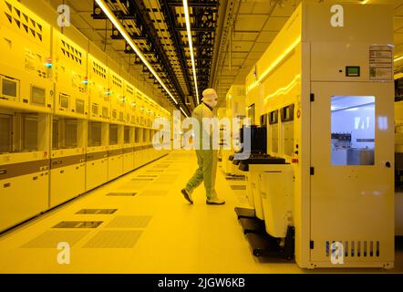 Dresden, Deutschland. 12.. Juli 2022. Ein Mitarbeiter steht während einer Pressetour zum „Bosch Tech Day“ im Halbleiterwerk an einer Maschine zur Beschichtung von Wafern mit Gold. Kredit: Robert Michael/dpa/Alamy Live Nachrichten Stockfoto