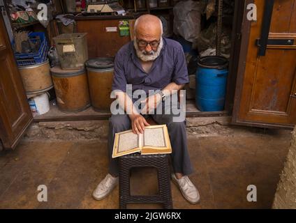 Muslimischer Mann, der den koran im alten Souk, im Norden des Governorats, in Tripolis, im Libanon liest Stockfoto