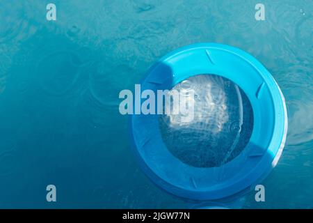 Draufsicht auf den Skimmer zur Reinigung des Pools im klaren Wasser. Nahaufnahme des Skimmers auf einem Rahmenbecken Stockfoto