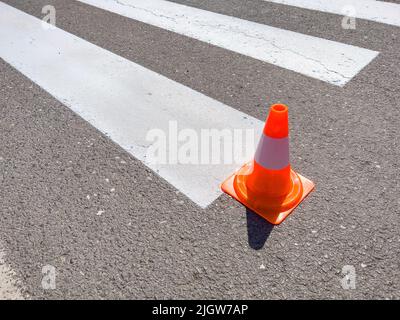 Zebra überquert Markierungsfarbe auf der Straße und orange Kegel auf der Straße Stockfoto