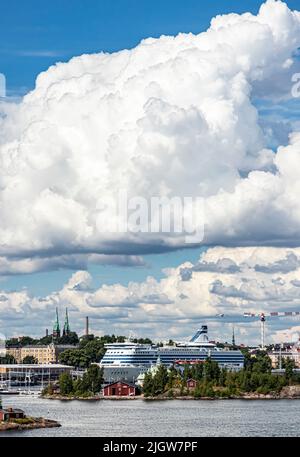 Die m/s Silja Serenade Cruisefähre am Olympia Terminal des Hafens von Helsinki an einem Sommertag. Im Vordergrund die Insel Valkosaari. Stockfoto