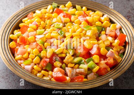 Sweet Corn Chaat ist ein würziger, würziger und schmackhafter Snack, der aus gedämpftem oder gekochtem Mais, Zwiebeln, Tomaten, Kräutern und Gewürzen auf einem Teller in der Nähe auf t zubereitet wird Stockfoto