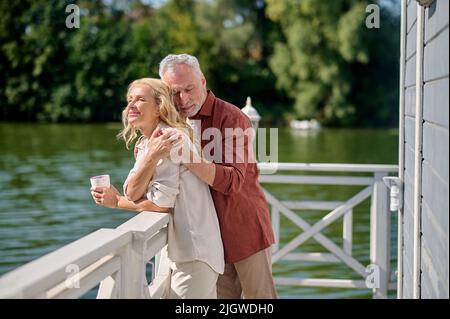 Mann und Frau verbringen Zeit in der Nähe des Flusses und schauen glücklich und romantisch Stockfoto