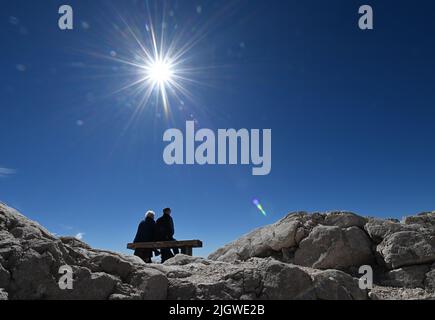 Grainau, Deutschland. 13.. Juli 2022. Urlauber genießen die Sonne auf dem Zugspitzplatt. Die warmen Temperaturen belasten diesen Sommer den Überbleibsel des nördlichen Schneeferners auf der Zugspitze. Quelle: Angelika Warmuth/dpa/Alamy Live News Stockfoto