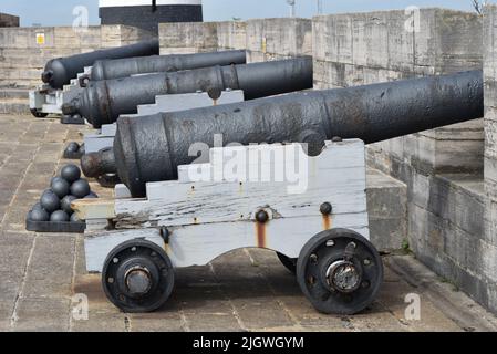 Eine Reihe mittelalterlicher Kanonen und Kanonenkugeln auf den Wällen von Southsea Castle. Stockfoto