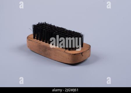 Schuhputzpinsel mit Holzgriff auf hellblauem Hintergrund Stockfoto