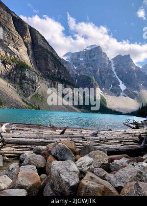 Purpurblaue Berge und türkisblauer Bergsee mit wunderschönen Felsen vor einem wolkenblauen Himmel am Moraine Lake Stockfoto