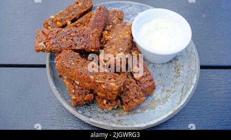 Schwarzes Knoblauchbrot mit Sauce. Perfekter Snack mit Bier. Stockfoto