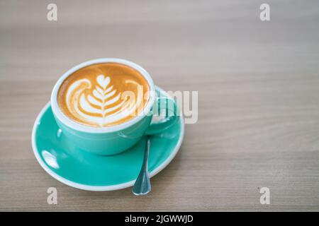 Heißer Latte Art Kaffee in grüner Tasse auf Holztisch Aroma Drink Stockfoto