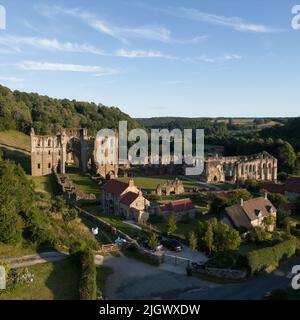 Luftbild der Drohne mit niedriger Höhe von außerhalb des Geländes. Die Abtei von Rievaulx ist eine ausgedehnte Ruine, die ursprünglich vom Zisterzienserordens erbaut wurde Stockfoto