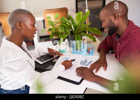 Ein Finanzberater und Kunde besprechen die Portfolioperformance Stockfoto