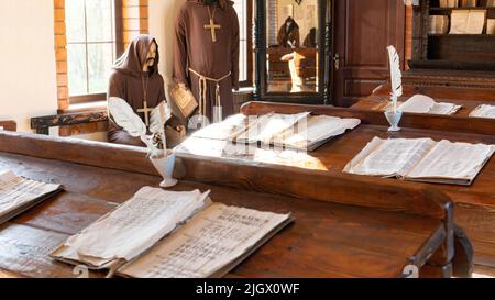 Bildung im Mittelalter Konzept. Unterricht in einer mittelalterlichen Universität mit Jesuitenmönchen als Lehrer. Alte Manuskripte und Papier mit Federkiel Stockfoto