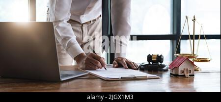 Nahaufnahme junger Geschäftsmann in der Nähe des Tisches mit Stift in den Händen, bereit Unterzeichnung profitables Angebot Vereinbarung nach Überprüfung der Vertragsbedingungen Stockfoto