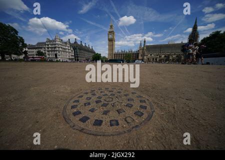 Die ausgetrockte Erde in der normalerweise grünen Umgebung des Parliament Square, Westminster, London. Das Met Office warnt davor, dass das Vereinigte Königreich bei steigenden Temperaturen und „tropischen“ Nächten schwelen wird, da die Hitzewelle Anfang nächster Woche zugreift. Bilddatum: Mittwoch, 13. Juli 2022. Stockfoto