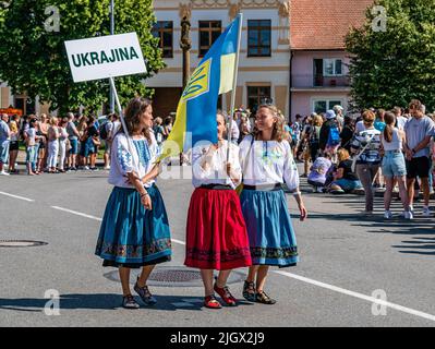 Straznice, Tschechische Republik - 25. Juni 2022 Internationales Folklore-Festival drei ukrainische Mädchen mit einer Flagge in Volkstrachten Stockfoto