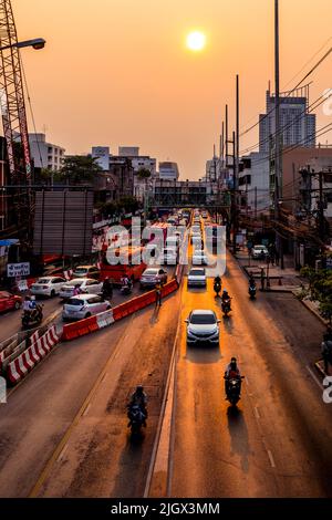 Bauverkehr in Bangkok in der Nähe von Sonnenuntergang mit Sonne und Lgiht auf der Autobahn reflektiert. Stockfoto