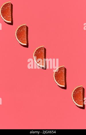 Muster aus bunten kandierten Früchten orange Zitrone auf Korallen Hintergrund. Flach liegend. Minimalkonzept Stockfoto
