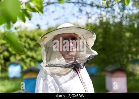 Nahaufnahme eines lächelnden Imkers mit Schutzkleidung auf einer Farm Stockfoto