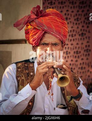 Jaipur, Rajasthan, Indien - 05. April 2022: Porträt des Mannes in rajasthani, der Trompete spielt. Stockfoto
