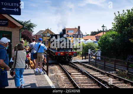 Ein Blick auf Menschen, die an einem Sommertag auf dem Bahnsteig am Bahnhof von Sheringham laufen Stockfoto