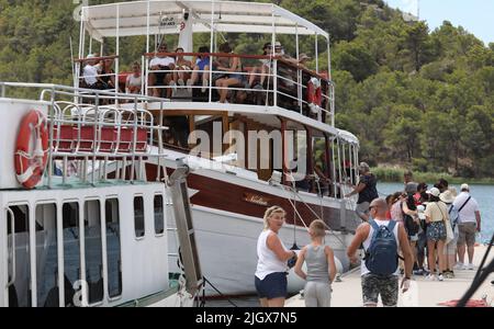 Gruppen von Touristen gesehen in Skradin, Kroatien am 13. Juli 2022. In Skradin warten Touristen auf die Touristenboote, die sie zum Nationalpark Krka, zu den Wasserfällen des Flusses Krka, bringen. Foto: Dusko Jaramaz/PIXSELL Stockfoto