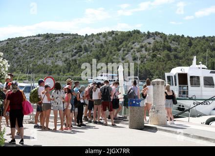 Gruppen von Touristen gesehen in Skradin, Kroatien am 13. Juli 2022. In Skradin warten Touristen auf die Touristenboote, die sie zum Nationalpark Krka, zu den Wasserfällen des Flusses Krka, bringen. Foto: Dusko Jaramaz/PIXSELL Stockfoto