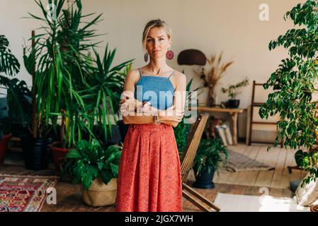 Portrait einer wunderschönen blonden Frau, die im authentischen Wohnzimmer steht Stockfoto