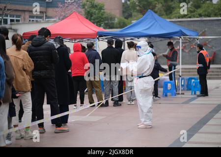 Shanghai, China-März 19. 2022: Viele Chinesen stellen sich vor, um Nukleinsäuretest auf Covid-19-Coronavirus in der lokalen Gemeinschaft zu erhalten. Shanghai ist See Stockfoto