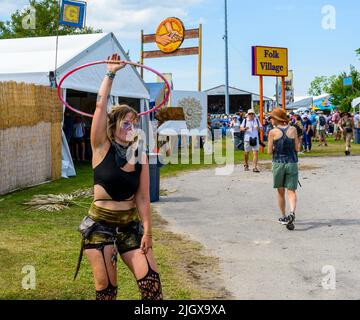 NEW ORLEANS, LA, USA - 29. April 2022: Frau tanzt mit einem Hula Hoop Reifen beim New Orleans Jazz and Heritage Festival 2022 Stockfoto