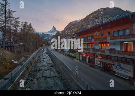 ZERMATT, SCHWEIZ - APR 11, 2022: Eine Landschaft des Matterhorns bei Sonnenuntergang mit dem Fluss Matter Vispa im Vordergrund. Stockfoto