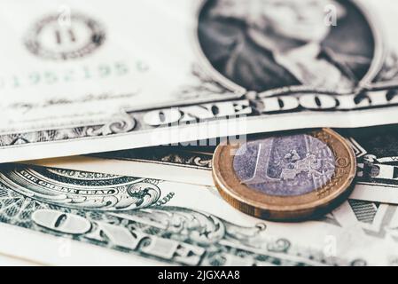 Eine Euro-Münze auf US-Dollar-Scheine, Parität und Währungswechselkurskonzept Stockfoto