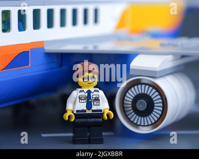 Tambow, Russische Föderation - 30. Juni 2022 Eine Minifigur eines Lego-Piloten, die auf einem Flughafen vor einem Passagierflugzeug steht. Stockfoto
