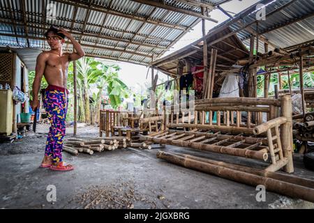 Moalboal, Philippinen. 13.. Juli 2022. Ein Zimmermann macht eine Pause, während er seine Möbel macht. Tägliches Leben im Moalboal District, Cebu, Philippinen. Das Gebiet, das einst für sein Tauchen und seine massiven Sardinenwolken bekannt war, hat sich schwer getan, den Tourismus wieder zu beleben, auch nachdem die Reisebeschränkungen von Covid-19 aufgehoben wurden, da die Infrastruktur durch den Taifun Rai, auch bekannt als Super Typhoon Odette, beschädigt wurde, was einen Großteil des Gebiets dezimiert und mit dem Wiederaufbau zu kämpfen hat. (Foto von Matt Hunt/SOPA Images/Sipa USA) Quelle: SIPA USA/Alamy Live News Stockfoto