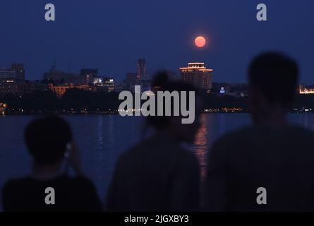 Hangzhou, Chinas Provinz Zhejiang. 13.. Juli 2022. Bürger sehen einen Supermond am Westsee in Hangzhou, der ostchinesischen Provinz Zhejiang, 13. Juli 2022. Quelle: Long Wei/Xinhua/Alamy Live News Stockfoto