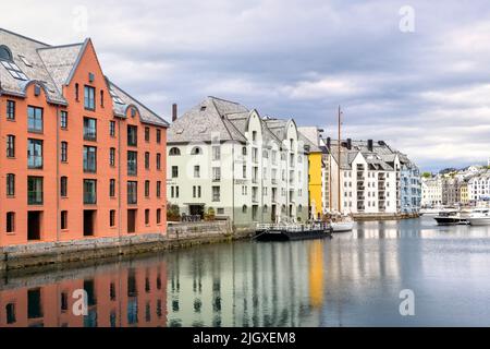 Bunte Gebäude und Spiegelungen rund um den Hafen und Kanal Alesund Norwegen Stockfoto