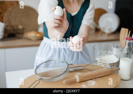 Mädchen Konditorin hält Hühnereier in ihren Händen Stockfoto