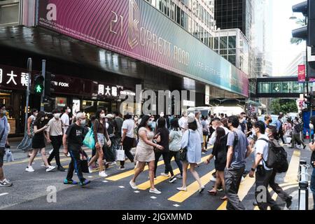 Hongkong, China. 13.. Juli 2022. Menschen mit Gesichtsmaske überqueren während der Geschäftszeiten die Straße. (Bild: © Keith Tsuji/ZUMA Press Wire) Stockfoto