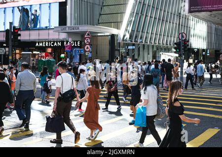 Hongkong, China. 13.. Juli 2022. Menschen mit Gesichtsmaske überqueren während der Geschäftszeiten die Straße. (Bild: © Keith Tsuji/ZUMA Press Wire) Stockfoto