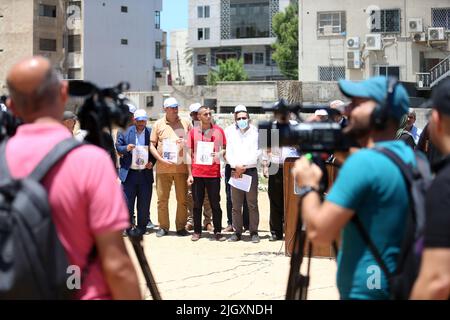 Gaza-Stadt, Palästina. 13.. Juli 2022. Palästinensische Journalisten halten während eines Protestes in Gaza Plakate mit der Aufschrift „Gerechtigkeit für Schireen“. Palästinensische Journalisten organisierten einen Protest, um Gerechtigkeit oder den palästinensischen Journalisten Shireen Abu Aklei, der letzten Monat in der Stadt Jenin getötet wurde, zu fordern. Sie demonstrieren vor dem heutigen Besuch des amerikanischen Präsidenten Joe Biden in Israel und den palästinensischen Gebieten. Stockfoto