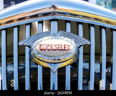 Nahaufnahme des klassischen beleuchteten Grillabzeichens aus Chrom auf dem Oldtimer von Wolseley Stockfoto