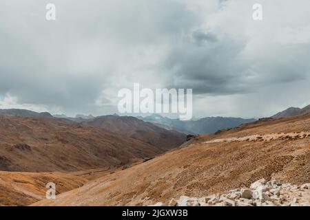 Berglandschaft mit dunklen Regenwolken im Deosai Nationalpark in Pakistan Stockfoto