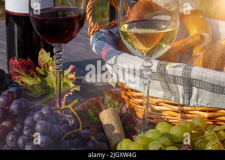 Symbolbild: Reife Trauben, verziert mit Weingläsern auf einem Holztisch Stockfoto