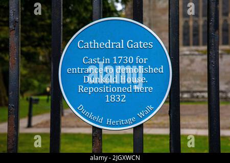 Dunkeld, Schottland - 11. 2021. Oktober: Eine blaue Tafel, die die Geschichte der Cathedral Gates of Dunkeld Cathedral in Dunkeld, Schottland, darstellt. Stockfoto