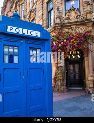 Glasgow, Schottland - Oktober 15. 2021: Eine alte blaue Police Box mit dem Restaurant Ivy im Hintergrund, in der Stadt Glasgow, Schottland. Stockfoto