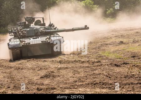 Moderner polnischer Kampfpanzer PT-91 bei Militärdemonstrationen. Eine Demonstrationsfahrt eines Militärfahrzeugs auf dem Feld. Stockfoto